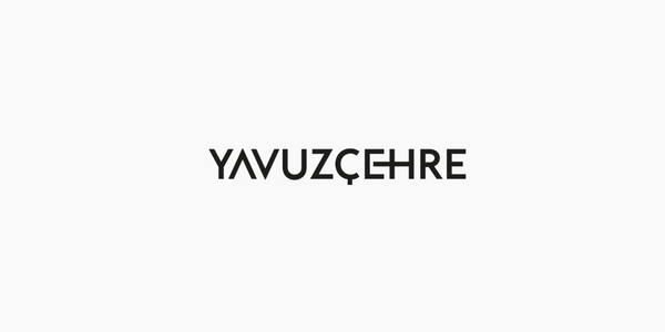 Açık gri arkaplan üzerine koyu gri Yavuzçehre logosu
